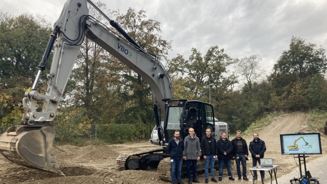 Die fünf Studenten des Masterstudiengangs Software Engineering der Universität Ulm mit dem Bagger, den sie programmiert haben.
