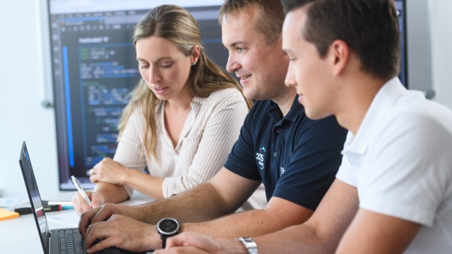 IT-Systemkaufleute arbeiten gemeinsam an einem Laptop