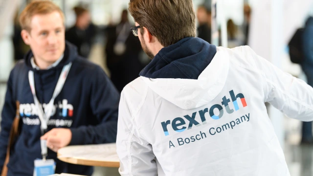 Ein Rexroth-Mitarbeiter wird von hinten gezeigt und unterhält sich mit einem anderen Menschen