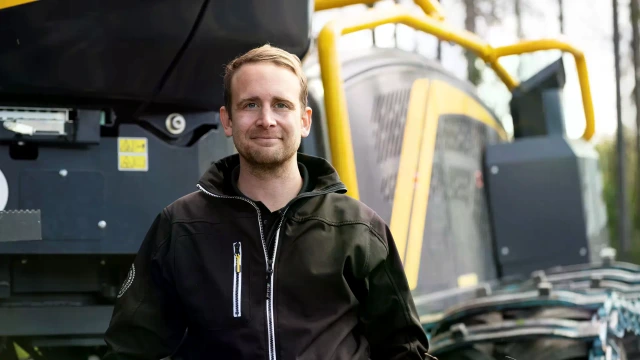 Kuva Emilistä metsäkoneen edessä