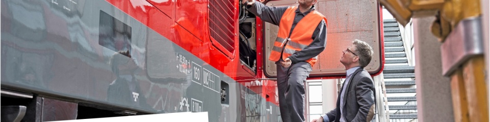 A serviceman and a elegantly dressed man stand next to a train; the date of the webinar is February 7, 2024