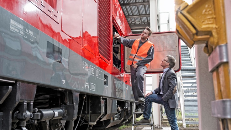 serwisant i elegancko ubrany mężczyzna stoja przy pociągu