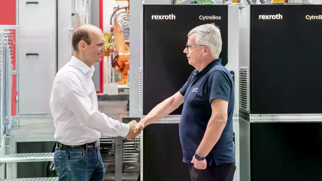 Två män skakar han framför CytroBox aggregat
