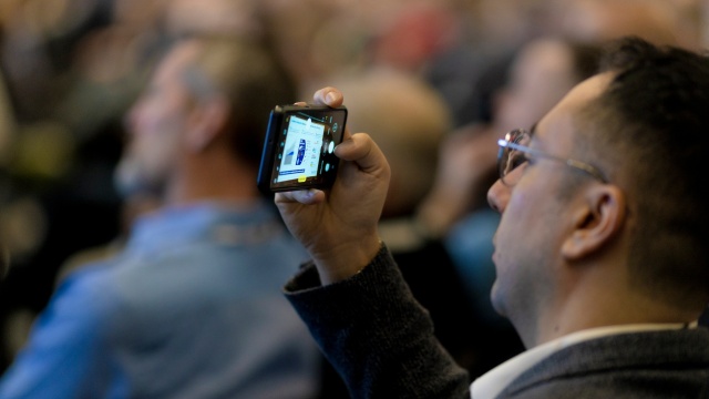 En man tar en bild med sin telefon på Bosch Rexroth Forum