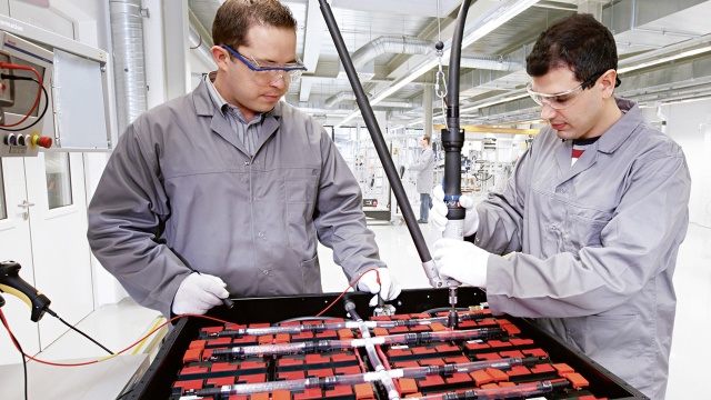 Two people working on battery production line