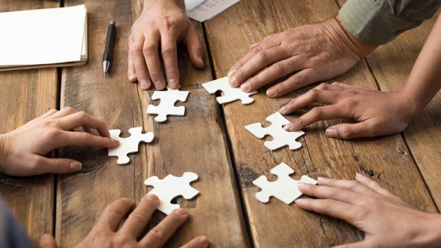 Hands collaborating on puzzle