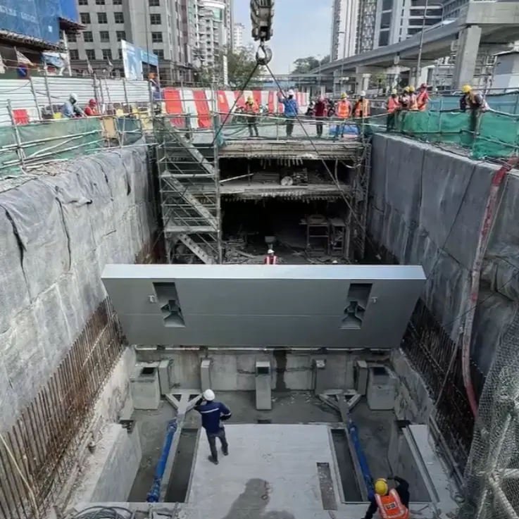 Chantier à Kuala Lumpur, où un bloc de béton massif est en cours d'installation.