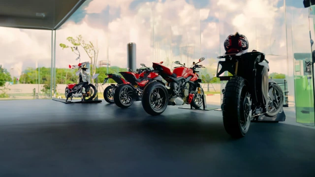 Ducati Motorräder in einer Reihe bei einem Händler, mit Bäumen im Hintergrund.