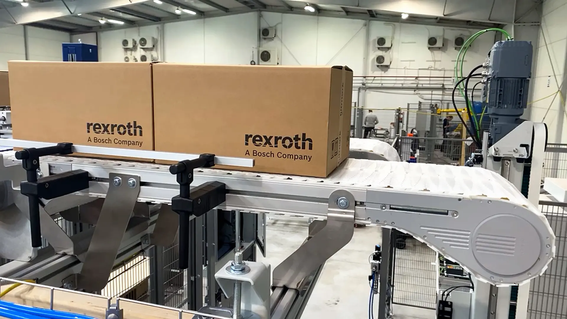 Two Rexroth cartons on a white VarioFlow plus conveyor belt with a smooth chain surface