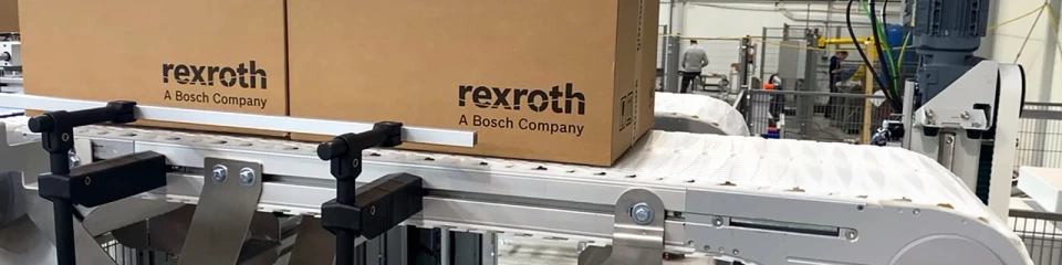 Two Rexroth cartons on a white VarioFlow plus conveyor belt with a smooth chain surface