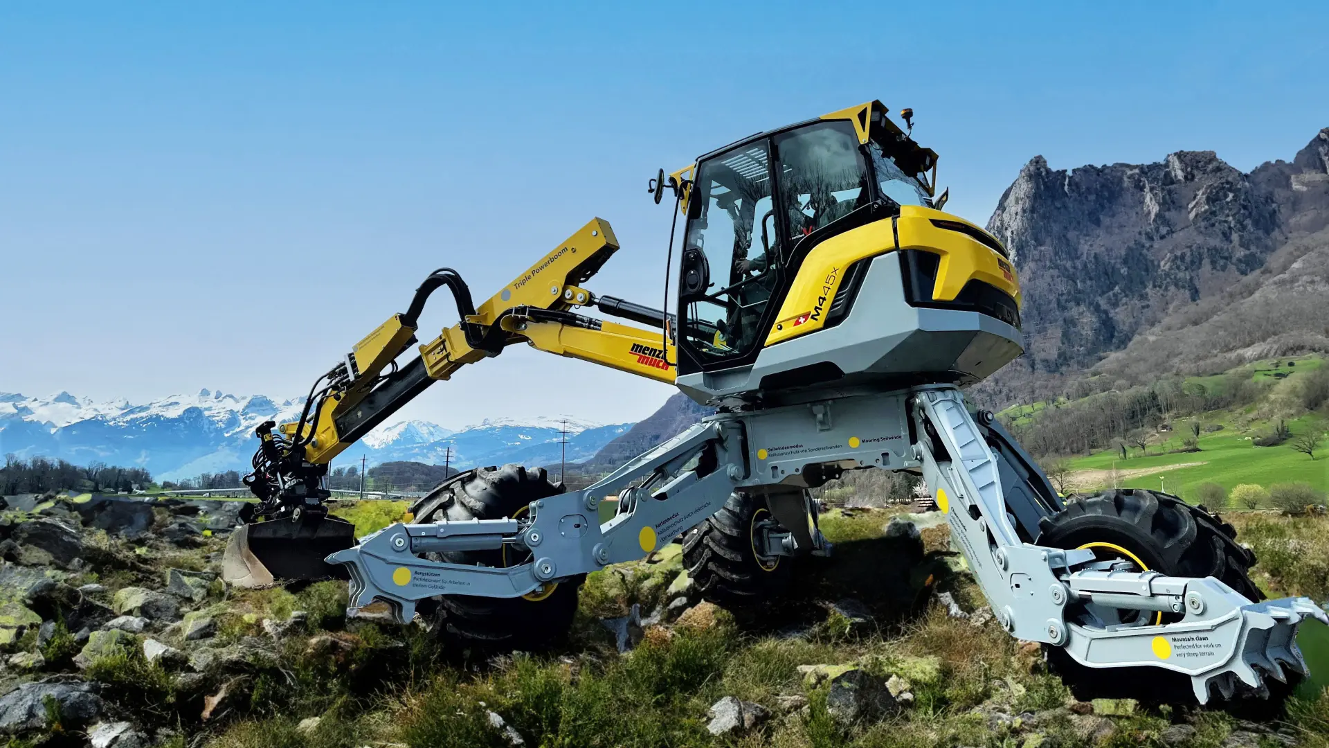 yellow-grey Menzi Muck M4x walking excavator in the mountains