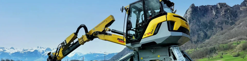 yellow-grey Menzi Muck M4x walking excavator in the mountains
