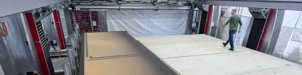 A voxeljet VX9000 3D printer filled with sand, with a person walking on it