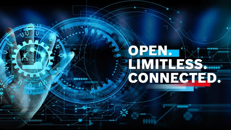 Các bánh răng lồng vào nhau trên nền tối bên cạnh yêu cầu "Open.Limitless.Connected" bằng chữ màu trắng