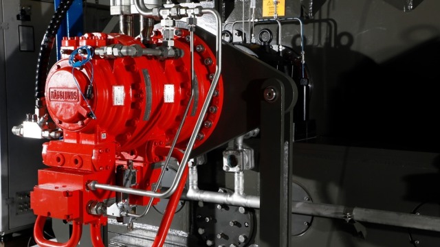 En rød Hägglunds-motor på en knuser til jordoliekoks