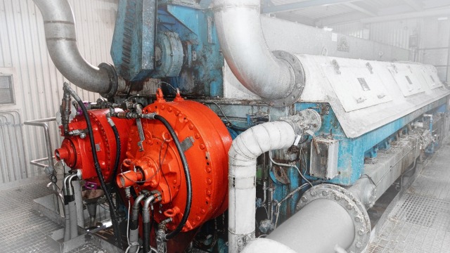 Dois motores Hägglunds vermelhos em uma prensa de lavagem em uma fábrica de papel