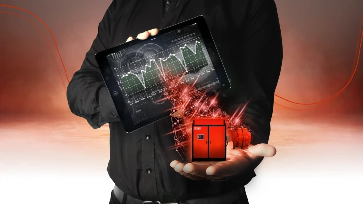 Man holding Hägglunds direct drive system and a tablet with a graph of drive system data from condition monitoring service.