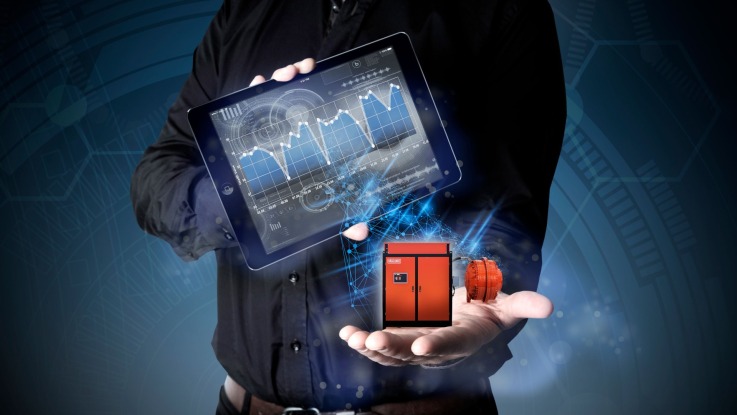 Man holding Hägglunds direct drive system and a tablet with a graph of drive system data from condition monitoring service.