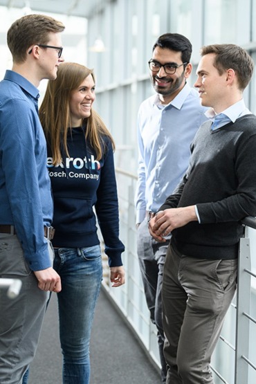 four people are talking and grinning