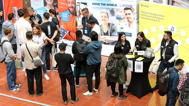 keyvisual Karrieretag study&stay zeigt eine volle Halle mit Studierenden und Unternehmen in Gesprächen