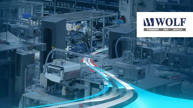 Packaging machinery in a factory with the WOLF logo.