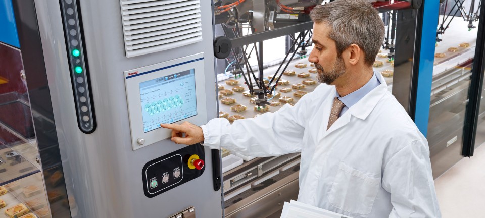 Maschinenbediener startet Produktion einer Lebensmittel-Verpackungsmaschine.