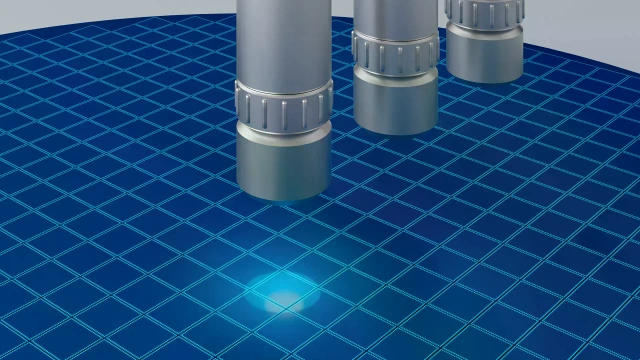 Drei zylindrische Metallsonden, die über einem blau gemusterten Siliziumwafer positioniert sind.