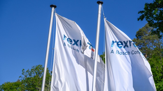 Two flags with the Bosch Rexroth logo in front of a Bosch Rexroth building in Lohr.
