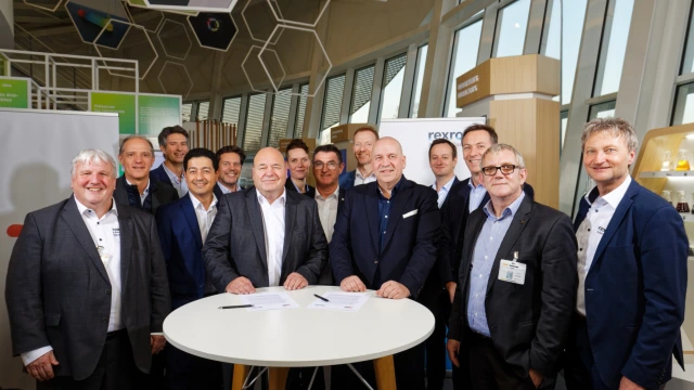 At the signing in Lyon: Dr. Steffen Haack, CEO of Bosch Rexroth (at the table, right), Rainer Keiemburg, Vice President Greases & Specialties, TotalEnergies Lubricants (at the table, left).