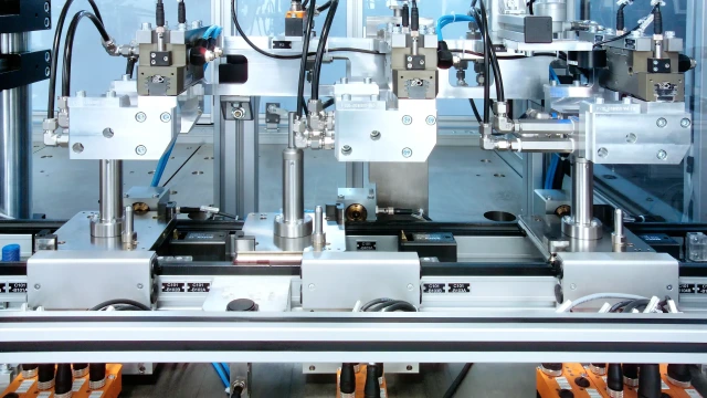 A close-up of multiple precision assembly stations operating on the Bosch Rexroth TS 1 transfer system