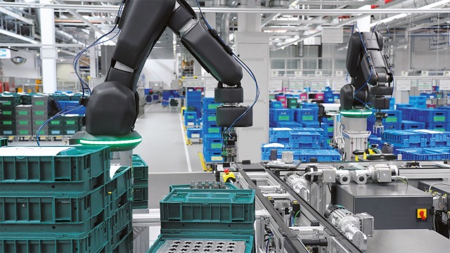 Robot APAS firmy Bosch Rexroth na linii montażowej; w tle strefa logistyki wewnątrzzakładowej
