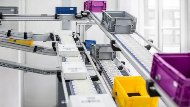 Three VarioFlow plus chain conveyor belts with packed boxes