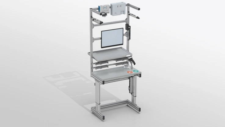 Mobiler Arbeitsplatz mit Arbeitsplatte, Griffbehälter, Monitor. Oben montierte Kamera und 2 Hinweistafeln.