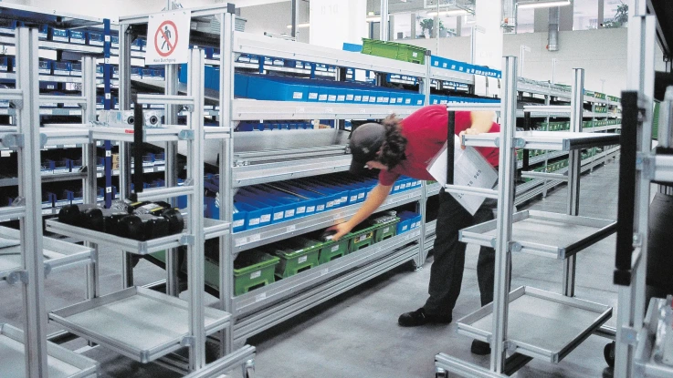 Material crates on feed conveyor that is slightly inclined forward