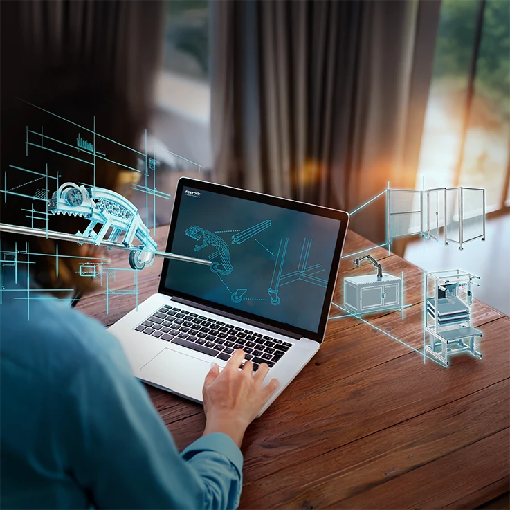 Person designing modular aluminum profile systems in CAD software on a laptop, surrounded by blueprints for conveyor systems, partitions, and workbenches.