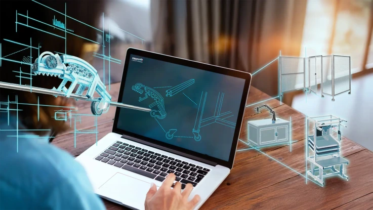 Person designing modular aluminum profile systems in CAD software on a laptop, surrounded by blueprints for conveyor systems, partitions, and workbenches.