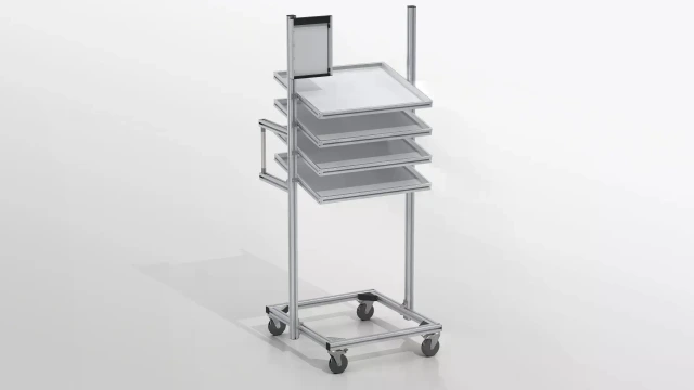 Trolley with 4 material levels, handrail, castors, and information board. In the front, an aluminum frame with tabletop on 4 vertical aluminum profiles and horizontal aluminum crossbars at the bottom.