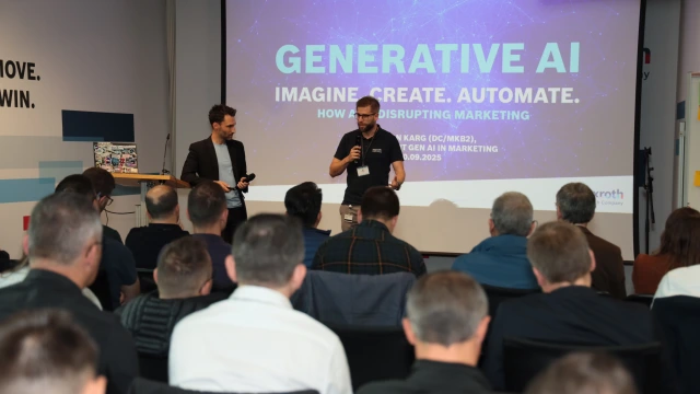 A person with a microphone in front of an audience during a presentation on the topic of "Generative AI".