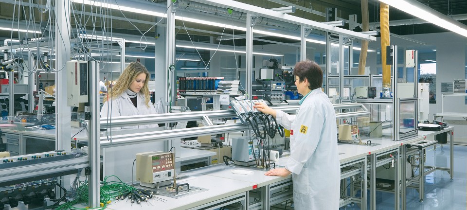 Doi angajați ai companiei Bosch Rexroth montează senzori de temperatură rezistenți la apă cu protecție ESD
