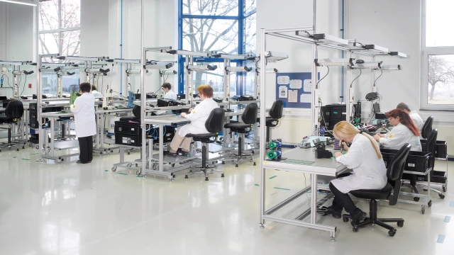 Employees working at ergonomic workstations with material supply according to kanban principle, ESD