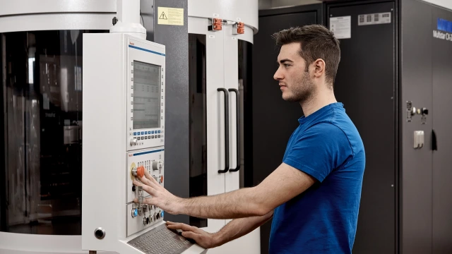 La imagen muestra a un técnico al lado de una máquina.