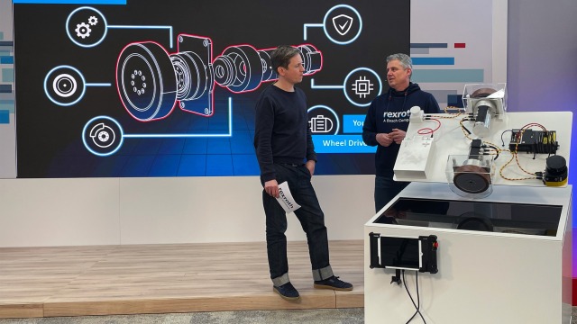 Bosch Rexrothin uuden liiketoiminnan johtaja Jörg Heckel ja valvoja seisomassa ROKIT-ctrlX AUTOMATION-esittelyn edessä kertomassa ROKIT-moottorista.