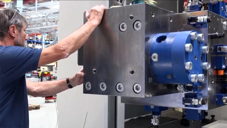 Employee working on a manifold for the hydraulics.