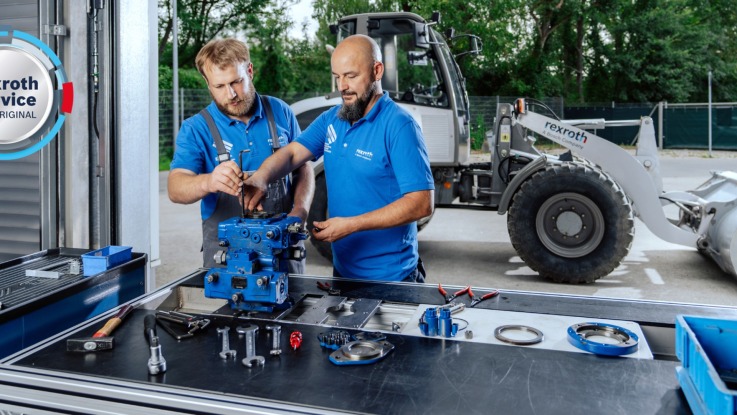 Two Service Mobile Solutions partners standing at a workbench