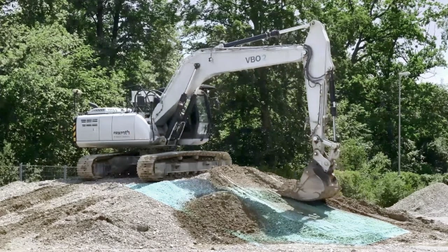 Tracked excavator on a pile moving material