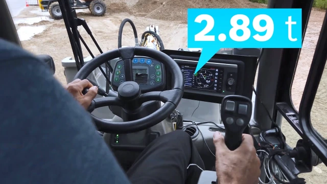 Small wheeled loader driving with a full shovel