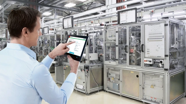A person uses the Digital Service Assistant on a tablet in front of a technical system.