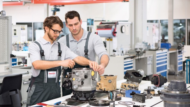 Doi angajați ai service-ului Bosch Rexroth repară o mașină