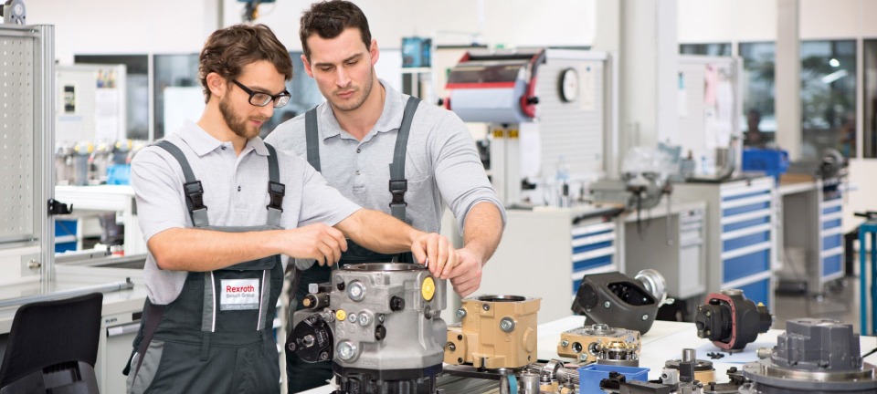 Twee servicemedewerkers van Bosch Rexroth repareren een machine