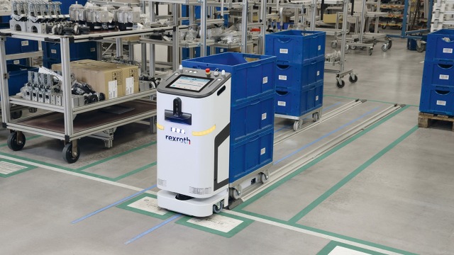 L’ACTIVE Shuttle de Bosch Rexroth soulève un chariot avec 4 petits supports de charge.